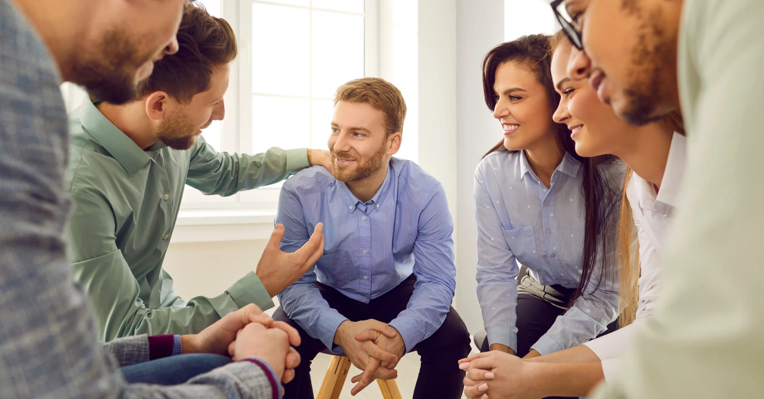A support group sitting in a circle talking after detox