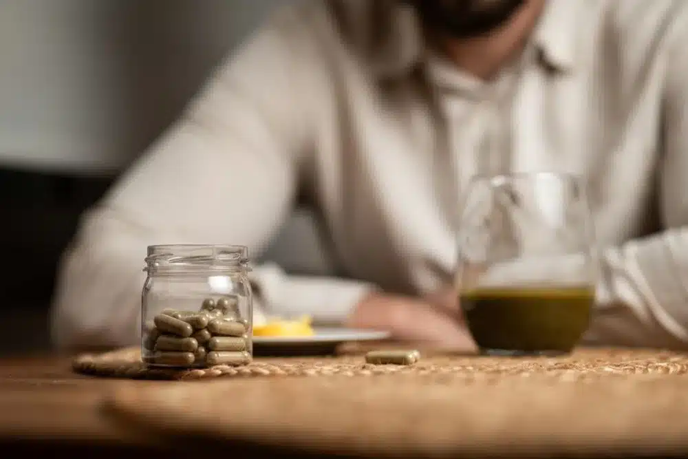 A jar of supplements beside a plate during detox intake